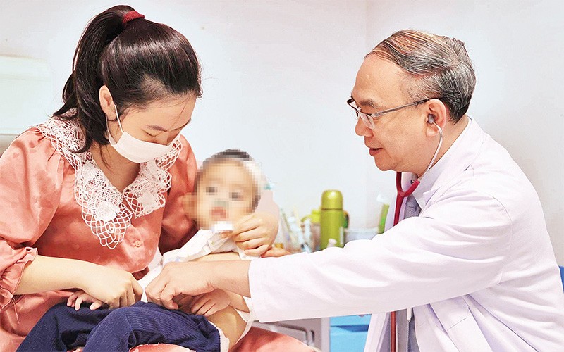 Phó Giáo sư, Tiến sĩ, Bác sĩ Vũ Chí Dũng khám cho bé Quang Thanh. 