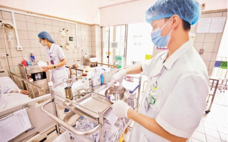 Nhân viên y tế Bệnh viện Bạch Mai thăm khám, phát thuốc điều trị cho bệnh nhân. (Ảnh DUY ĐĂNG)