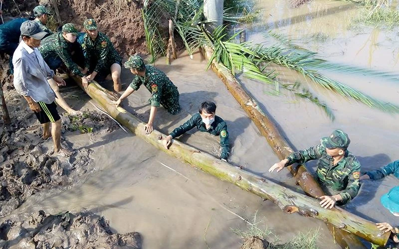 Cán bộ, đoàn viên Chi đoàn Đồn Biên phòng An Thạnh Ba, Bộ đội Biên phòng tỉnh Sóc Trăng giúp dân khắc phục hậu quả do thiên tai gây ra.