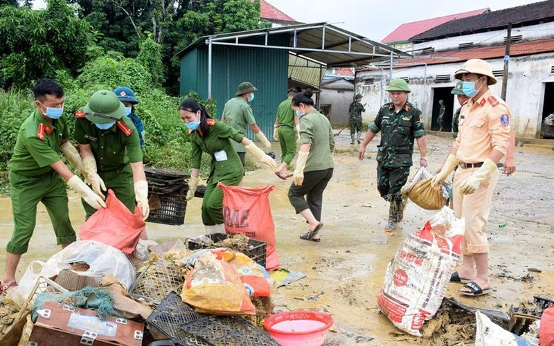 Lực lượng công an, quân đội, dân quân tự vệ giúp người dân xã Thanh Mỹ, huyện Thanh Chương vệ sinh môi trường sau mưa, lũ. (Ảnh XUÂN HOÀNG)