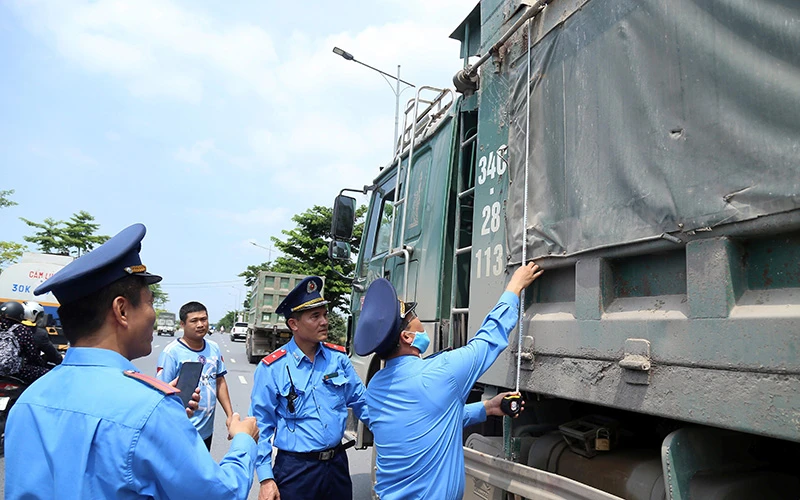 Thanh tra giao thông Hà Nội kiểm tra phương tiện cơi nới thành thùng, chở quá tải trên đường Lý Thánh Tông, huyện Gia Lâm. (Ảnh LÊ KHÁNH)