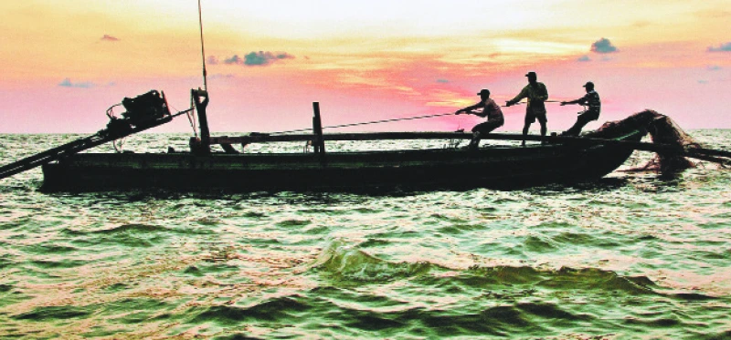 Ngư dân huyện Ngọc Hiển thu mẻ lưới sau cùng khi hoàng hôn buông xuống mặt biển tây nam.