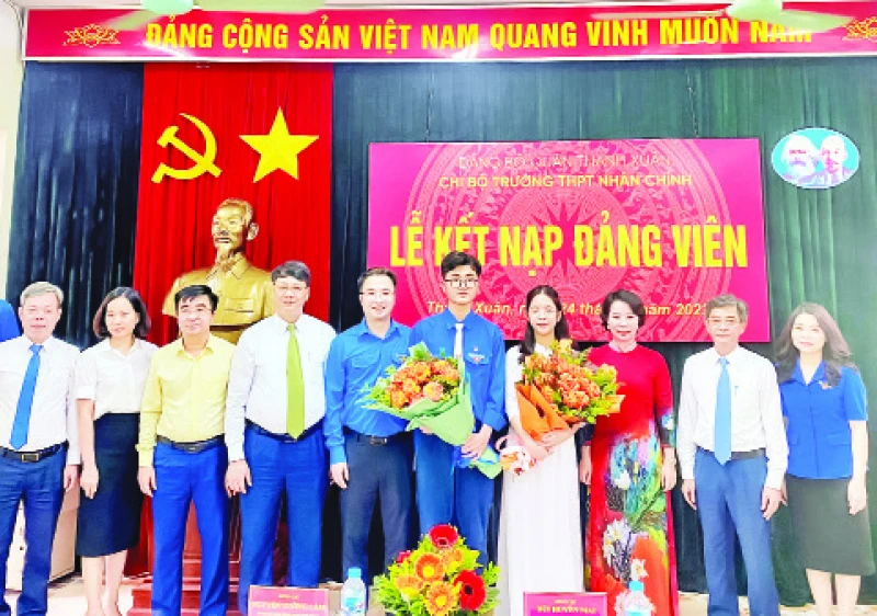 Bí thư Quận ủy Thanh Xuân, Bùi Huyền Mai và các đại biểu chúc mừng hai đảng viên trẻ tại Chi bộ trường THPT Nhân Chính. (Ảnh HỒNG THÁI)