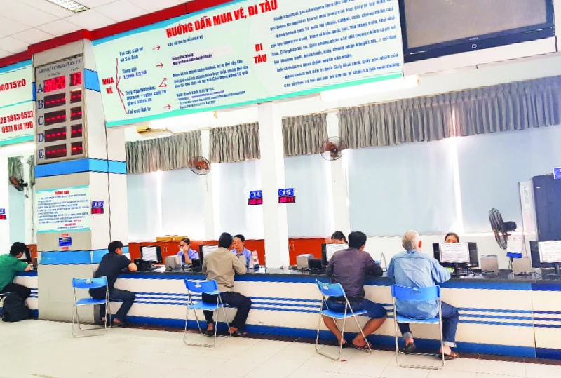Nhân viên ga Sài Gòn trả vé tàu Tết Giáp Thìn cho hành khách đặt mua trên hệ thống trực tuyến của ngành đường sắt và mua trực tiếp tại nhà ga.