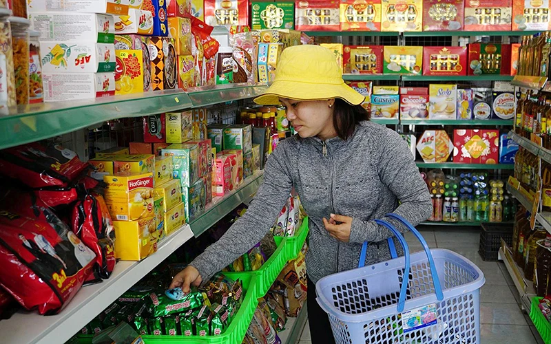 Người tiêu dùng mua sắm tại điểm bán hàng Việt Nam trên địa bàn huyện Châu Thành, tỉnh Tây Ninh. (Ảnh NHI TRẦN)