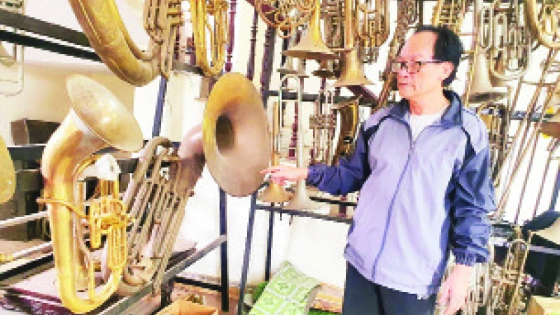 Ông Nguyễn Văn Đông bên “gia tài” là hàng trăm chiếc kèn tây các loại. 
