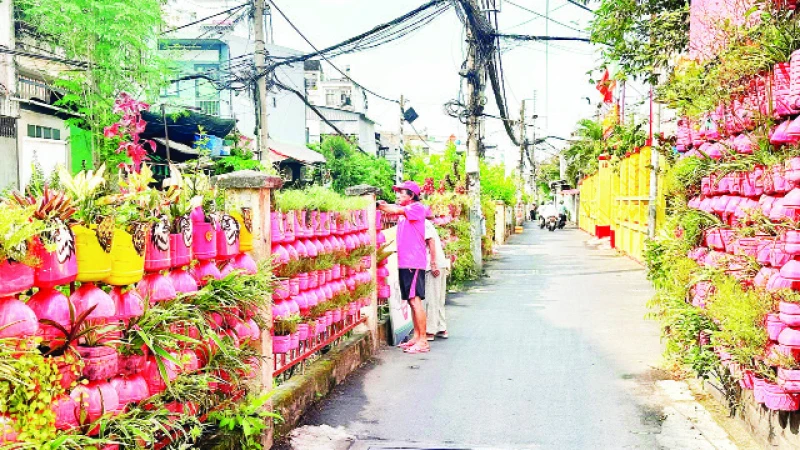 Người dân Phường 10, quận Phú Nhuận chăm sóc cây cảnh dọc tuyến đường nơi có đường sắt đi qua.