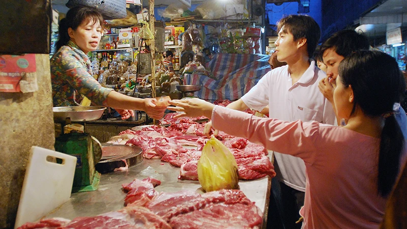 Người dân mua thực phẩm tại chợ Hôm-Đức Viên (Hà Nội). (Ảnh TRẦN HẢI)