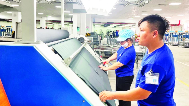 Công nhân làm việc trong dây chuyền sản xuất của Nhà máy dệt nhuộm TOP TEXTILES (Khu công nghiệp Dệt may Rạng Đông, huyện Nghĩa Hưng).