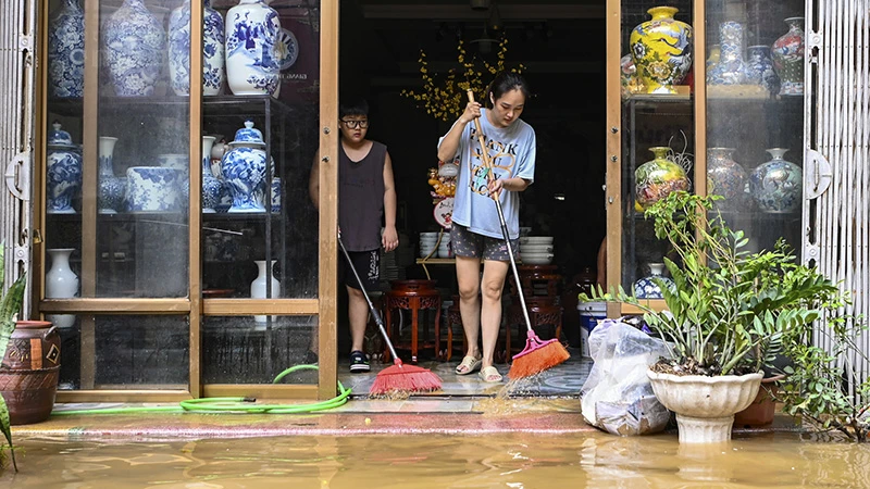 Sáng 13/9, nhiều hộ dân, tiểu thương tại xã Bát Tràng, huyện Gia Lâm, Hà Nội dọn dẹp bùn đất sau khi nước xuống. (Ảnh QUANG TÙNG)