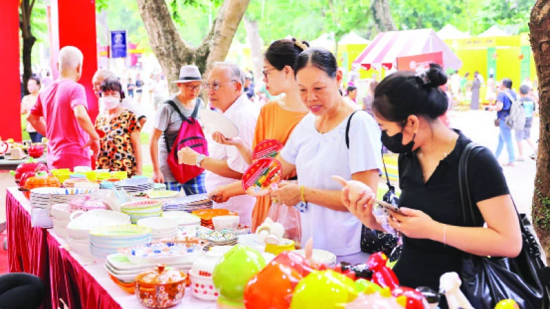 Khách du lịch tìm hiểu sản phẩm tại Lễ hội Quà tặng du lịch Hà Nội mới được tổ chức.