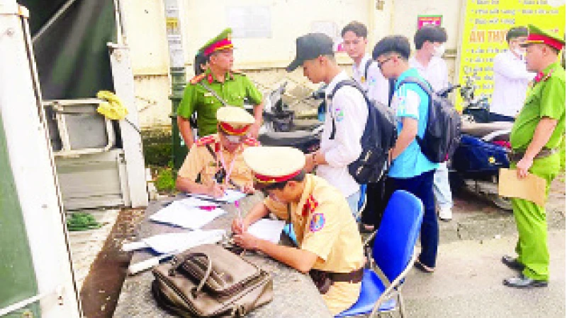 Học sinh vi phạm Luật Giao thông đường bộ bị Đội Cảnh sát giao thông-trật tự (Công an huyện Mỹ Đức) lập biên bản xử phạt. (Ảnh Phạm Công)