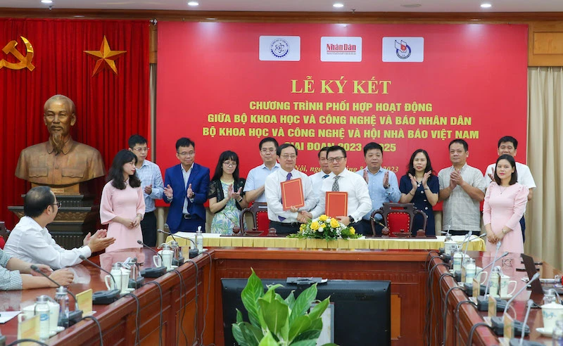 Tổng Biên tập Báo Nhân Dân Lê Quốc Minh và Bộ trưởng Khoa học và Công nghệ Huỳnh Thành Đạt trao biên bản ký kết.