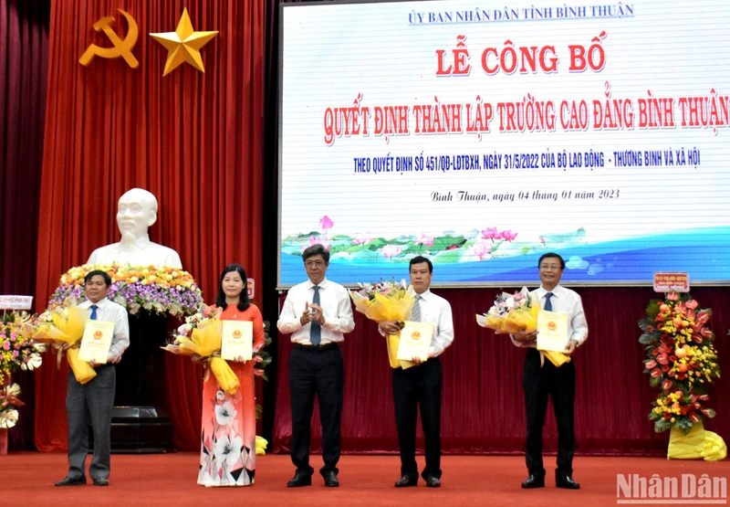 Phó Chủ tịch Ủy ban nhân dân tỉnh Bình Thuận Nguyễn Minh (đứng giữa) tặng hoa chúc mừng Ban Giám hiệu Trường Cao đẳng Bình Thuận.