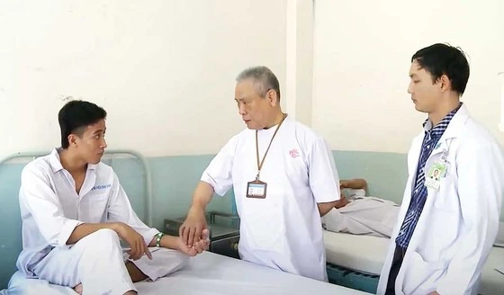 Giáo sư Văn Tần thăm khám cho người bệnh. (Ảnh: Bệnh viện Bình Dân)