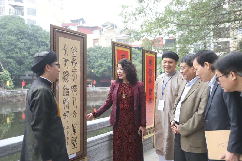 Các đại biểu tham quan triển lãm thư pháp bên hồ Văn.