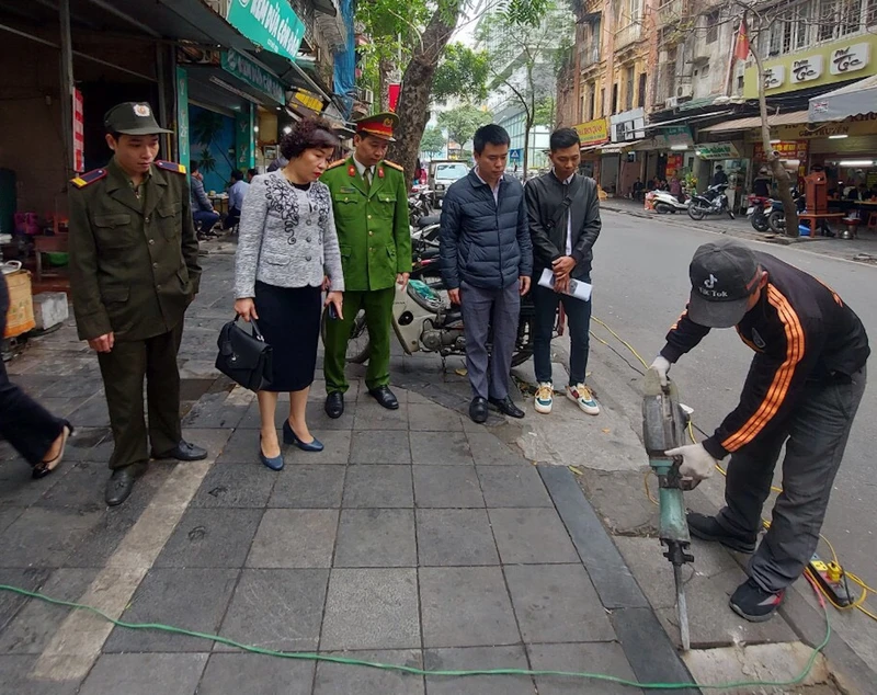 Lực lượng chức năng phá dỡ bục bệ vi phạm tại quận Hoàn Kiếm.