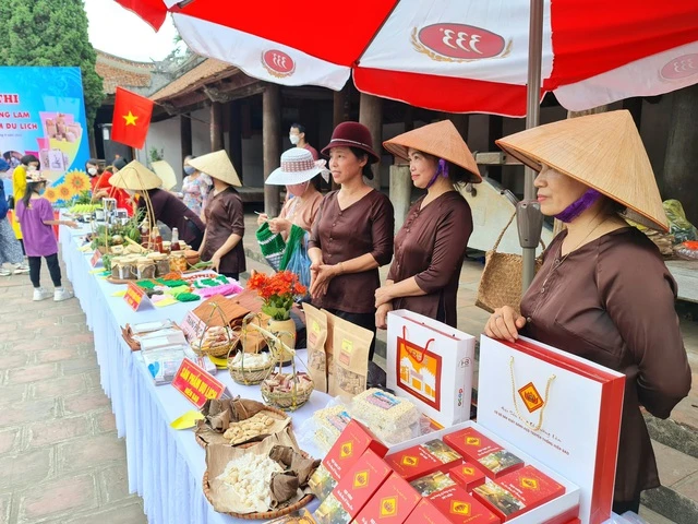 Người dân làng cổ Đường Lâm giới thiệu những đặc sản địa phương phục vụ khách du lịch.