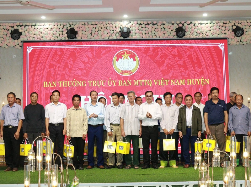 Lãnh đạo huyện và Ủy ban Mặt trận Tổ quốc Việt Nam huyện Mường La tặng quà cho đại diện người có uy tín.