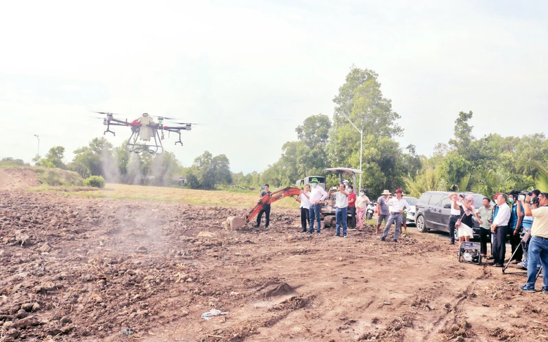 Người dân, doanh nghiệp đến tìm hiểu thiết bị không người lái, sử dụng phun thuốc bảo vệ thực vật trình diễn tại huyện Trà Cú. 