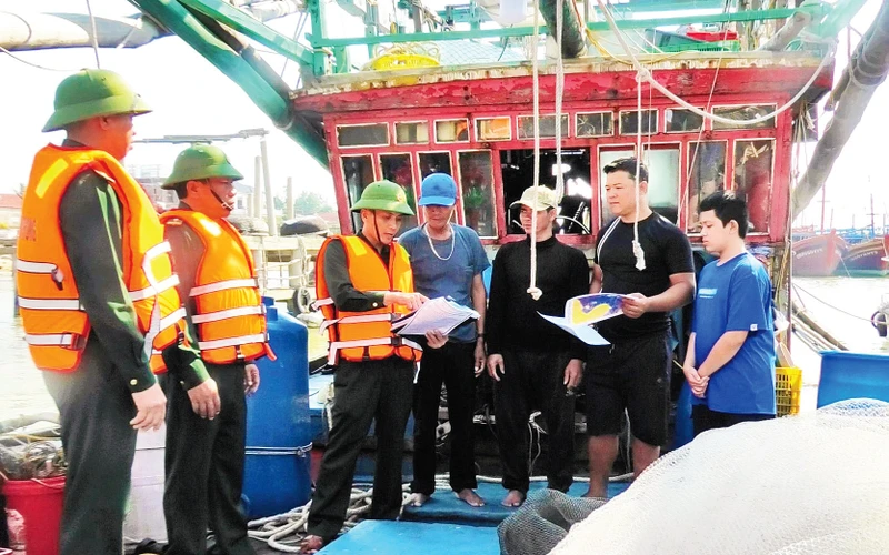 Bộ đội Biên phòng tỉnh Quảng Bình tuyên truyền cho ngư dân các quy định về chống khai thác IUU. (Ảnh HƯƠNG GIANG)