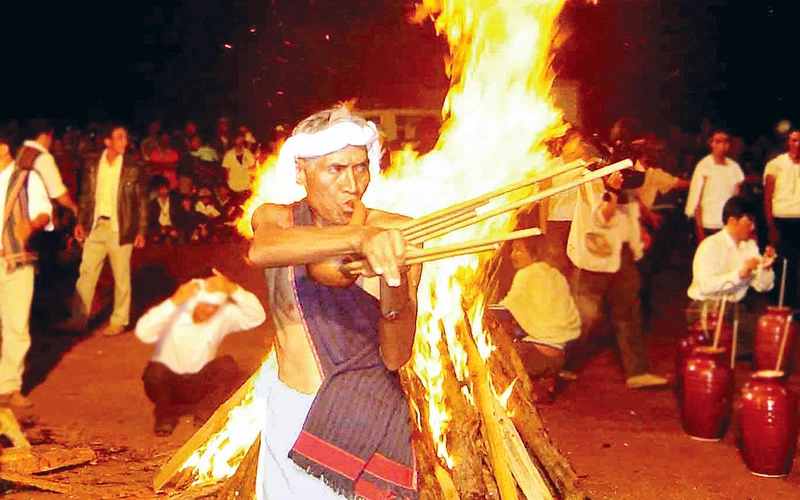 Già làng Chu Ru thổi rơkel trong ngày hội buôn làng. 