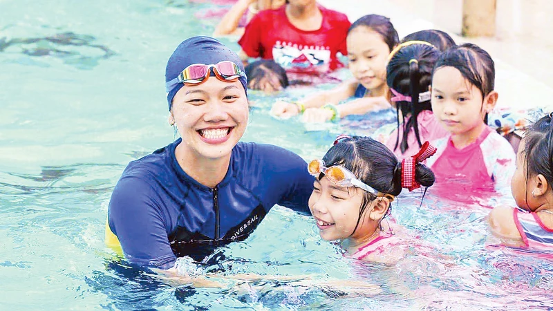 Ánh Viên hỗ trợ dạy bơi miễn phí cho các em nhỏ trong chương trình phòng chống đuối nước. Ảnh: Minh Tân 