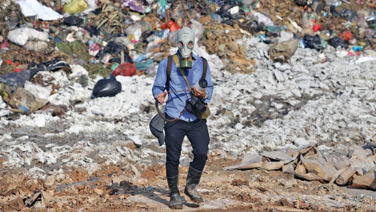 Phóng viên ảnh tác nghiệp trong môi trường độc hại tại bãi rác Nam Sơn, huyện Sóc Sơn, TP Hà Nội. Ảnh: Phạm Ngọc 