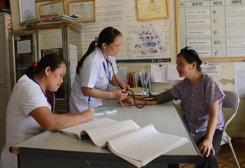Khám chữa bệnh, cấp phát thuốc bảo hiểm y tế cho người dân tại Trạm y tế xã Phong Nậm, huyện Trùng Khánh, tỉnh Cao Bằng. (Ảnh TUỆ NGHI)