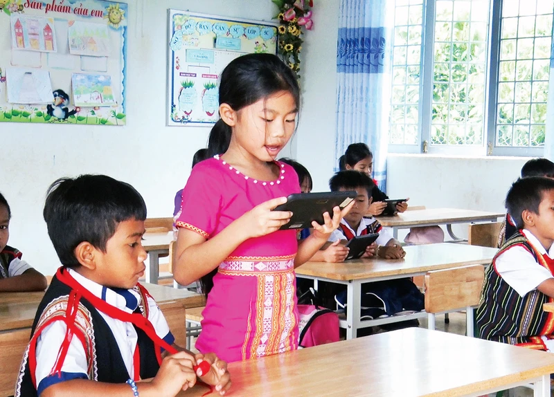 Học sinh Trường tiểu học và trung học cơ sở xã Đăk Ngọk sử dụng máy tính bảng phục vụ học tập. 