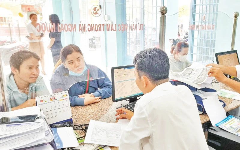 Cán bộ Trung tâm Dịch vụ việc làm tỉnh Vĩnh Long tư vấn cho người lao động tìm việc. 