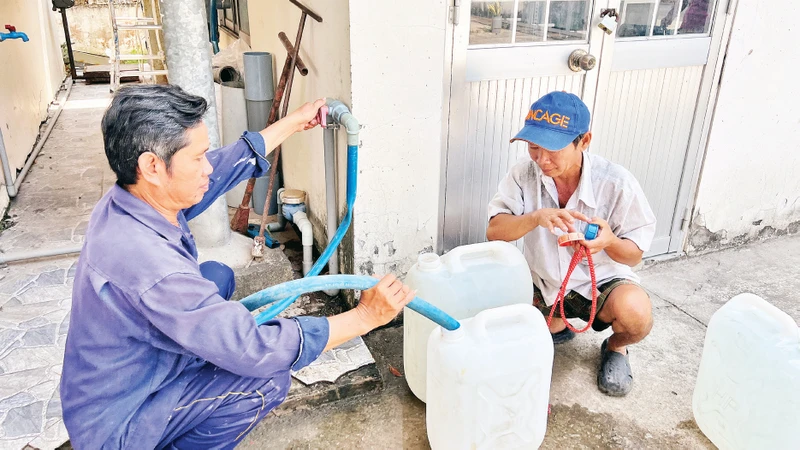 Người dân lấy nước ngọt miễn phí tại Nhà máy nước Lương Phú vì nước máy và nước kênh, rạch bị nhiễm mặn. 