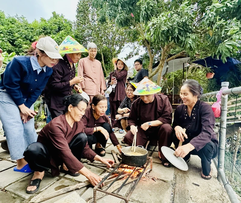 Khách du lịch trải nghiệm nấu bánh đúc khi đến với mô hình du lịch nông nghiệp tại Giang Biên (quận Long Biên, Hà Nội).