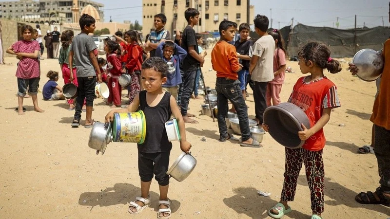 Trẻ em mất nhà cửa ở Gaza chờ nhận hàng cứu trợ. 