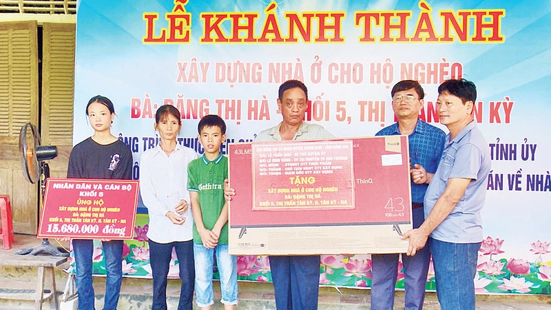 Khánh thành nhà Đại đoàn kết và tặng ti-vi cho gia đình bà Đặng Thị Hà ở Khối 5, thị trấn Tân Kỳ. (Ảnh Thanh Nhàn) 