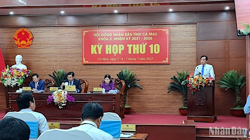 Chủ tịch Ủy ban nhân dân tỉnh Cà Mau Huỳnh Quốc Việt (đứng trên) tiếp phần trả lời chất vấn về nguyên nhân PCI giảm 26 bậc.