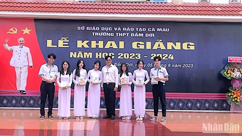 Hiệu trưởng Trường Trung học phổ thông Đầm Dơi (Cà Mau) trao tặng tập học sinh vận động từ Báo Nhân dân cho học sinh vượt khó học giỏi tại địa phương. 