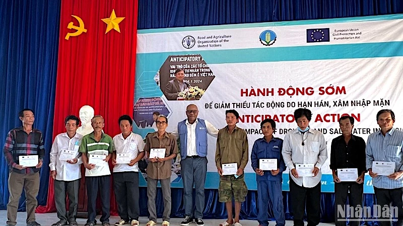 Đại diện tổ chức FAO tại Việt Nam trao hỗ trợ bằng tiền mặt cho người dân chịu ảnh hưởng bởi hạn-mặn tại Cà Mau.
