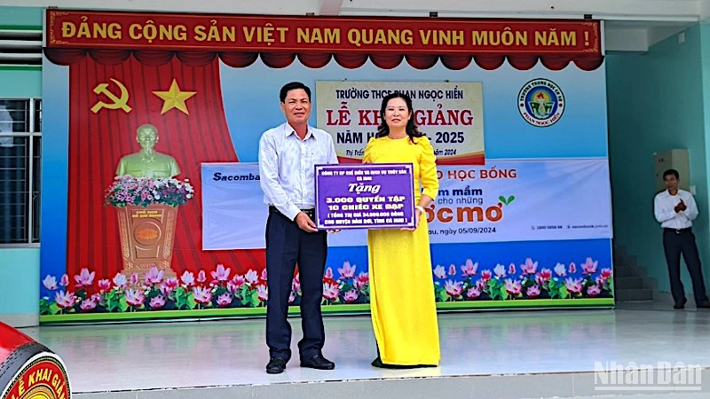 Đại diện chính quyền địa phương và đơn vị trường học tại huyện Đầm Dơi tiếp nhận hỗ trợ xe đạp và tập học sinh được vận động từ Báo Nhân Dân.