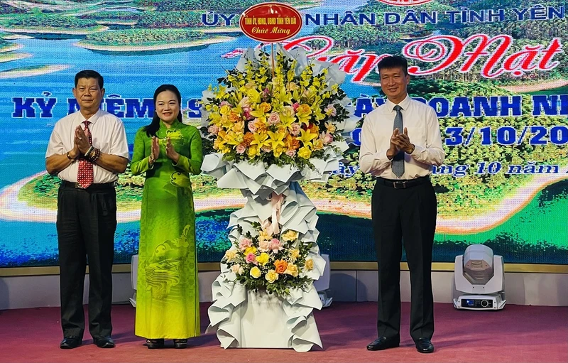 Chủ tịch Ủy ban nhân dân tỉnh Trần Huy Tuấn tặng hoa chúc mừng các doanh nghiệp trong tỉnh Yên Bái.