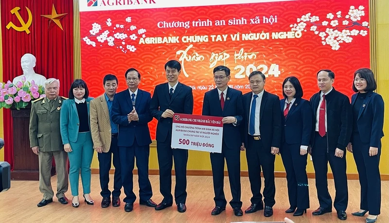 Giám đốc chi nhánh Agribank Bắc Yên Bái trao biểu trưng 500 triệu đồng cho người nghèo tỉnh Yên Bái. (Ảnh: THANH SƠN)