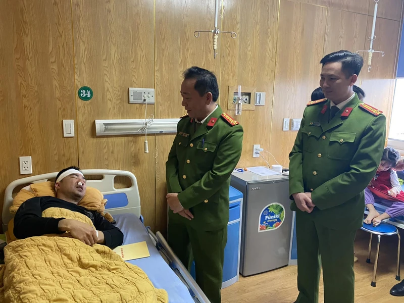 Đại tá Nguyễn Xuân Tuấn cùng lãnh đạo công an thành phố Yên Bái thăm, động viên Thượng úy Trần Trung Đức tại khoa Chấn thương. (Ảnh: THANH SƠN)