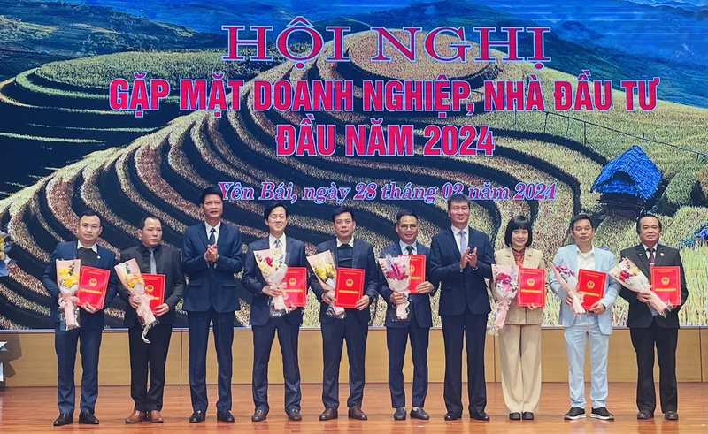 Chủ tịch Ủy ban nhân dân tỉnh Trần Huy Tuấn trao chứng nhận đầu tư cho các doanh nghiệp mới. (Ảnh THANH SƠN)