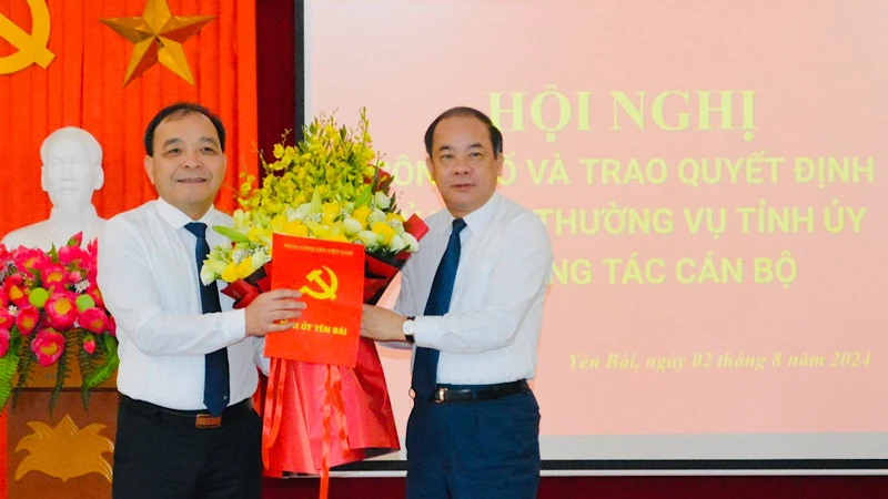 Phó Bí thư Thường trực Tỉnh ủy Tạ Văn Long (bên phải) trao quyết định Bí thư Đảng ủy Khối cơ quan và doanh nghiệp đối với đồng chí Trần Nhật Tân. (Ảnh: THANH SƠN)