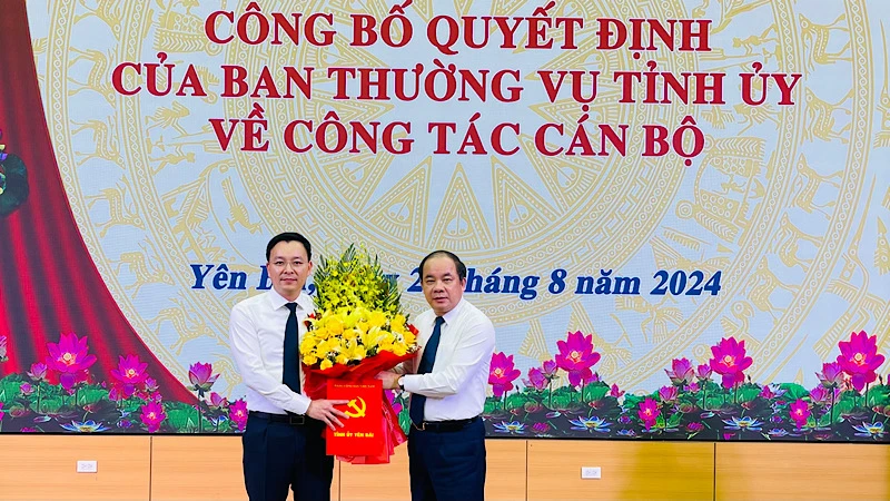 Đồng chí Tạ Văn Long, Phó Bí thư Thường trực Tỉnh ủy tặng hoa Chánh Văn phòng Tỉnh ủy An Hoàng Linh. (Ảnh: THANH SƠN)