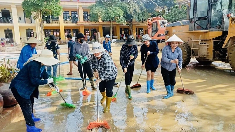 Giáo viên cùng các phụ huynh học sinh trường Minh Chuẩn, huyện Lục Yên vệ sinh sân trường sau bão số 3. (Ảnh: THANH SƠN)