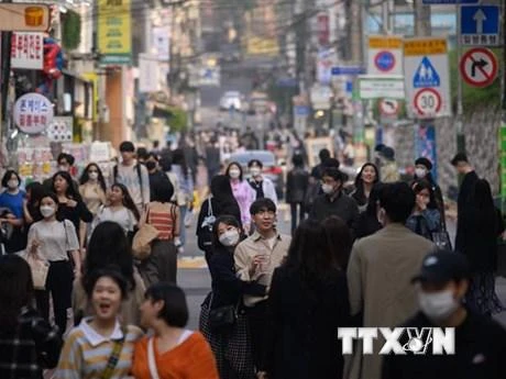 Người dân di chuyển trên đường phố tại Seoul, Hàn Quốc. (Ảnh: AFP/TTXVN)