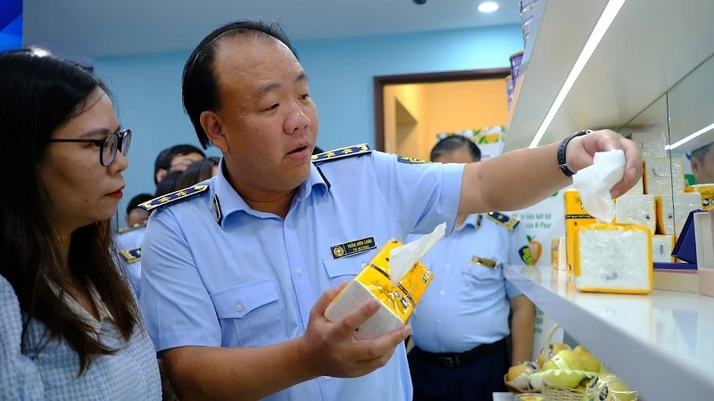 Tổng cục trưởng Quản lý thị trường Trần Hữu Linh giúp khách tham quan phân biệt sản phẩm giấy ăn thật - giả.