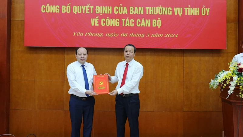 Đồng chí Nguyễn Quốc Chung, Phó Bí thư Thường trực Tỉnh ủy trao Quyết định điều động đồng chí Hoàng Bá Huy về Huyện ủy Yên Phong.