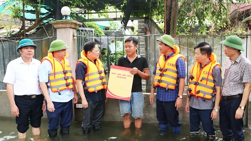 Đồng chí Bí thư Tỉnh ủy Bắc Ninh Nguyễn Anh Tuấn (thứ 3 từ trái sang) cùng các đồng chí lãnh đạo tỉnh tặng quà người dân đang bị lũ cô lập tại xã Hòa Tiến, huyện Yên Phong.